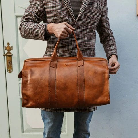 guy carrying brown leather bag